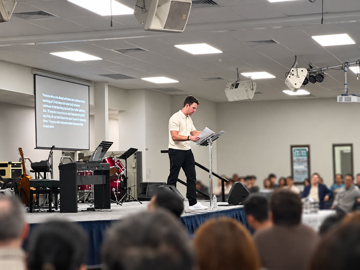 Jay Irwin speaking on stage to a large audience